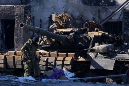 Soldado vistoria veículo militar danificado em rua de Mariupol, cidade ucraniana, que está ocupada por forças russas - Metrópoles
