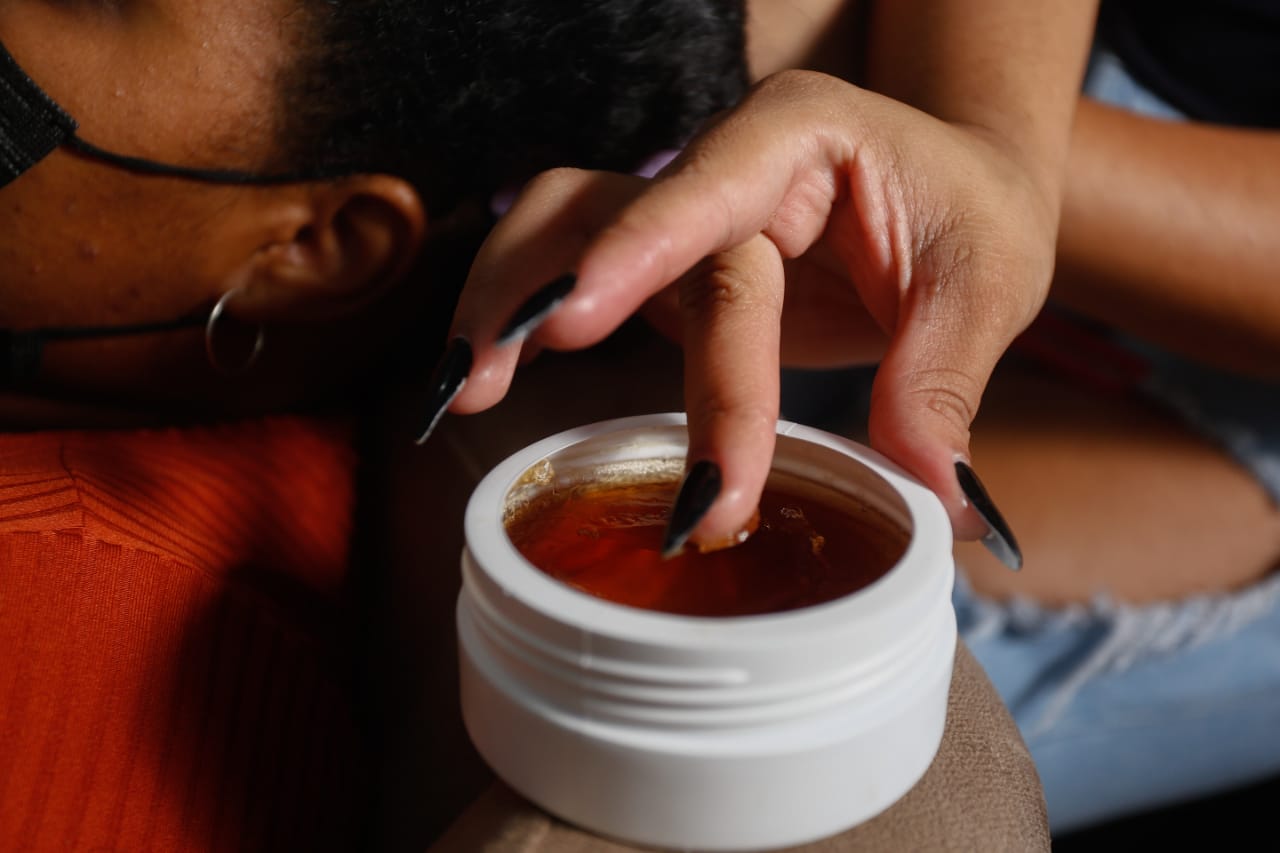 Trancista Késia Araújo demonstra o uso da pomada modeladora alergia crianças