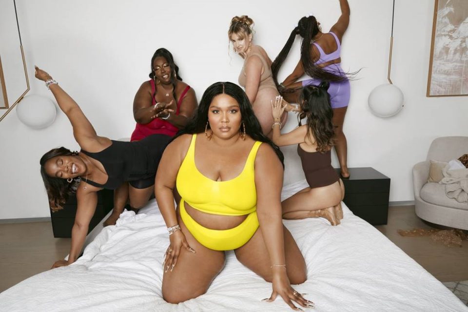 Lizzo e outras mulheres em cama usando lingeries