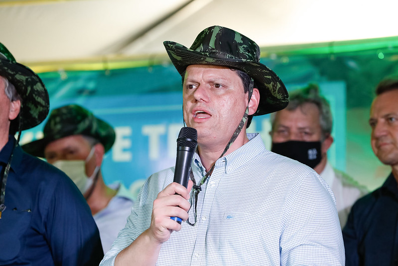 O ex-ministro da Infraestrutura, Tarcísio Gomes de Freitas, fala ao microfone em evento do governo. Ele usa chapéu com estampas militares - Metrópoles