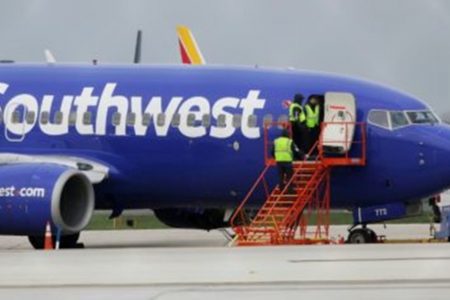 avião de uma empresa estadunidense. ele é azule branco e está no estacionamento de um aeroporto