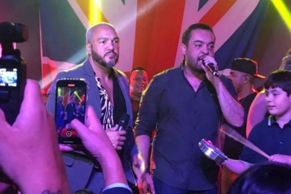 O cantor Belo, recém filiado ao PL, em evento ao lado do governador do Rio de Janeiro, de mesmo patido, Cláudio Castro. Ambos seguram microfone - Metrópoles