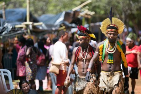 Indígenas trajados com adereços de sua etnia caminham em acampamento Terra Livre, no Eixo Monumental - Metrópoles