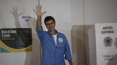 Marcelo Freixo, do PSOL, levanta a palma da mão aberta depois de sair de cabine de votação, acenando para jornalistas - Metrópoles