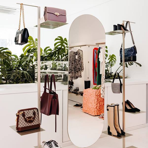 Vitrine com bolsas e sapatos de marcas renomadas expostos em nichos
