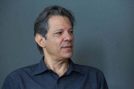 O pré-candidato ao governo de São Paulo, Fernando Haddad (PT), concede entrevista ao Metrópoles. Ele gesticula, sentado sob fundo cinza - Metrópoles