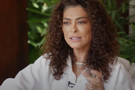 atriz Juliana Paes é entrevistada por Leo Dias. Ela usa uma camisa branca e tem os cabelos castanhos e cacheados