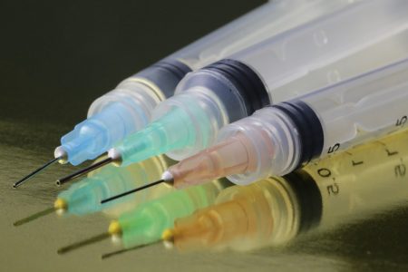 Seringas coloridas com agulhas em mesa - Metrópoles