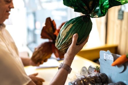 uma pessoa segura um ovo de páscoa com a embalagem verde