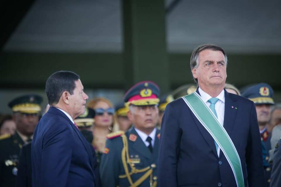 Bolsonaro olha para frente e o vice presidente Mourão presta continência ao seu lado, de perfil, na cerimônia militar em comemoração ao Dia do Exército, marcando os 374 anos da instituição - Metrópoles