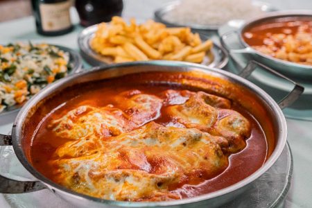 foto de parmegiana em panelinha e bandejas com batatas fritas