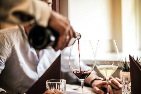 Homem servindo vinho tinto em taça
