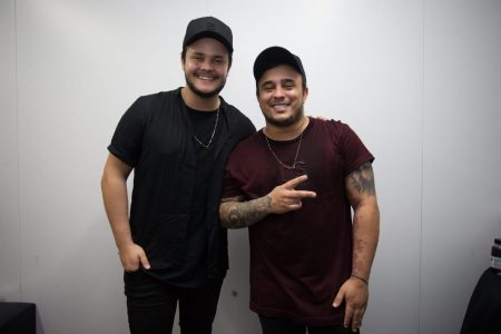 Foto da dupla Matheus e Kauan. Matheus está de blusa preta e Kauan de blusa vinho. Eles estão sorrindo para uma foto - Metrópoles