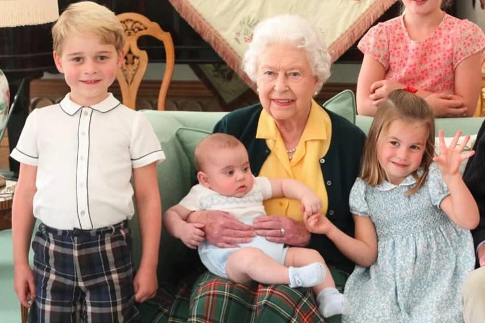 Foto colorida. Rainha Elizabeth, princesa Charlotte, príncipe George e príncipe Louis