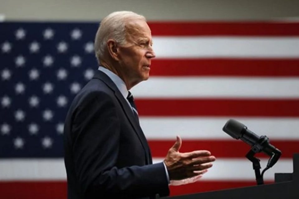 presidente dos EUA Joe Biden discursa em um palanque. é possível ver, em destaque, a bandeira do país ao fundo