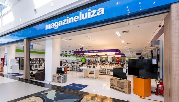 Facahada azul da loja varejista Magazine Luiza em um shopping, com diversos produtos à mostra - Metrópoles