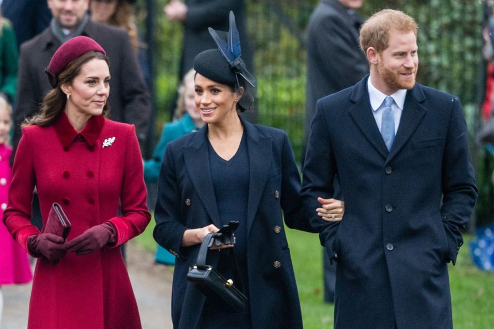 Foto colorida. Kate Middleton, Meghan Markle e príncipe Harry