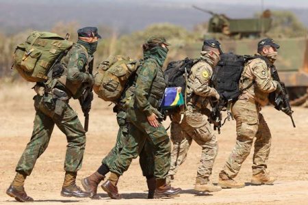 Fotografia colorida de quatro militares fardados