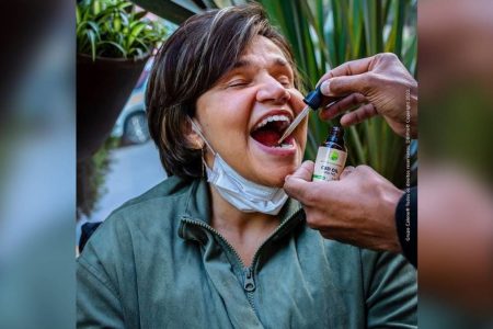 Foto colorida Claudia Rodrigues tomando canabidiol