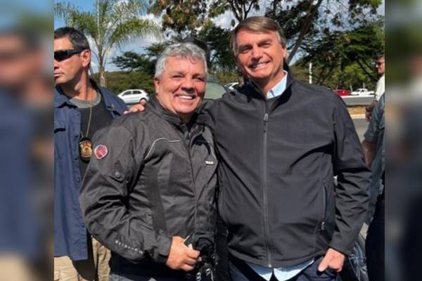 O ex-deputado Alberto Fraga ao lado do presidente Jair Bolsonaro. Ambos sorriem para a foto, usando roupas de motoqueiro - Metrópoles