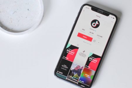 Celular com app TikTok aberto sob mesa branca - Metrópoles