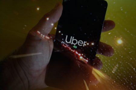 homem segura celular com aplicativo uber aberto