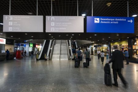 foto colorida de aeroporto com pessoas andando glo