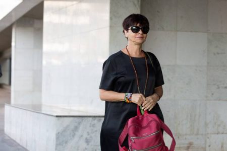imagem colorida de Adriana Villela de roupa preta no pilotis de um prédio