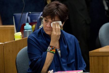 Fotografia colorida de mulher limpando o olho com um lenço