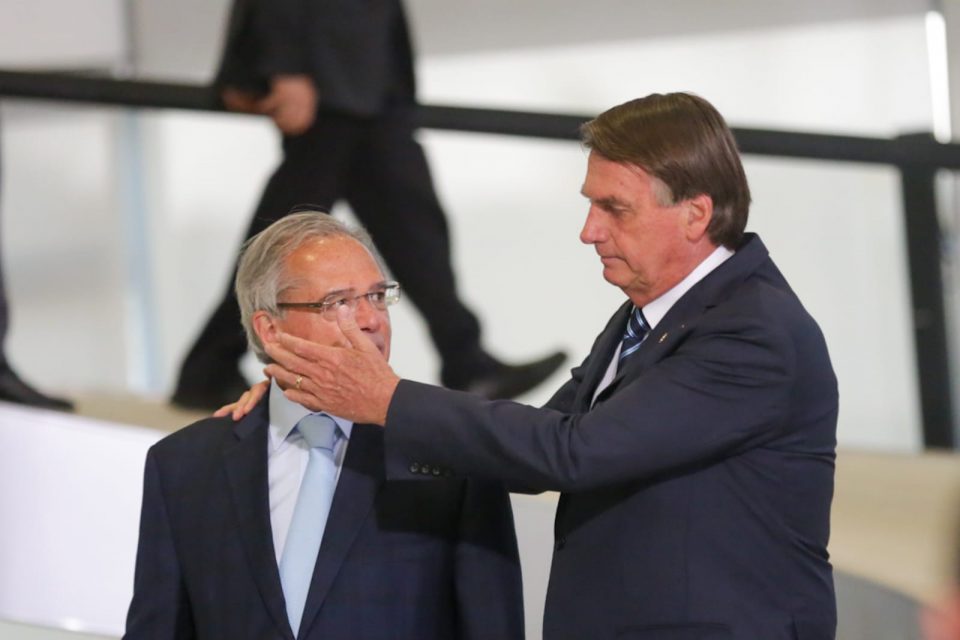 Presidente Jair Bolsonaro desce a rampa no Palácio do Planalto acompanhado do ministro da economia Paulo Guedes, durante cerimônia de lançamento do novo documento nacional de identidade