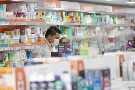 Funcionários trabalham dentro de farmácia