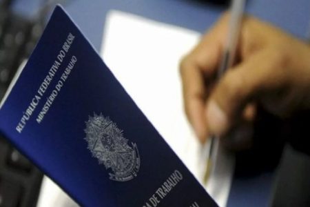 Pessoa segurando carteira de trabalho - Metrópoles