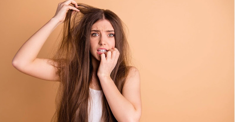 Mulher branca com a mão no cabelo
