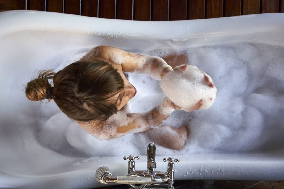 Mulher branca em banheira com espuma