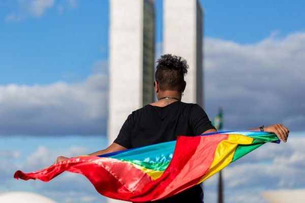 Pessoa segurando bandeira LGBT- Metrópoles