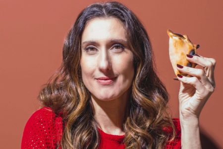 Chef Paola Carosella segurando uma empanada argentina - Metrópoles