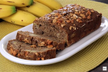 foto colorida de uma pão de banana marrom com castanha de caju