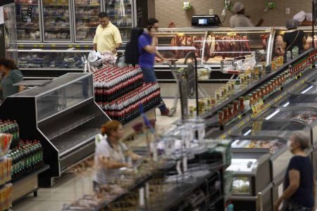 Pessoas circular pelo mercado proximo a bancada de carne