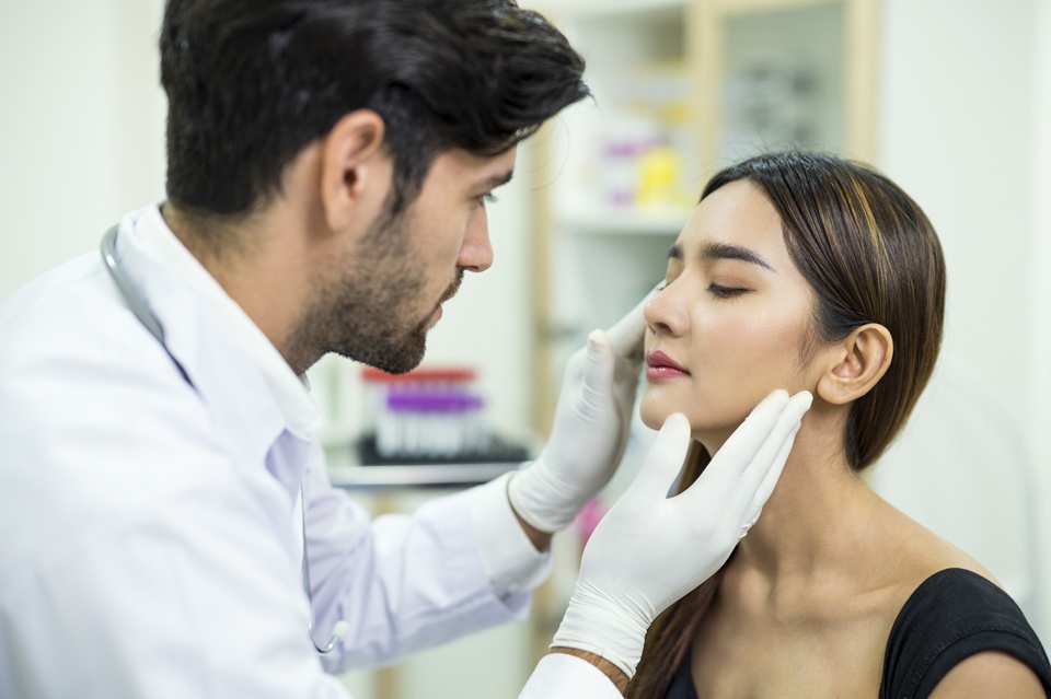 Médico analisando rosto de paciente mulher