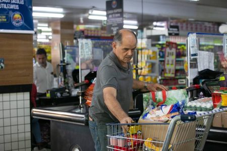 Homem careca coloca compras em carrinho - Metrópoles