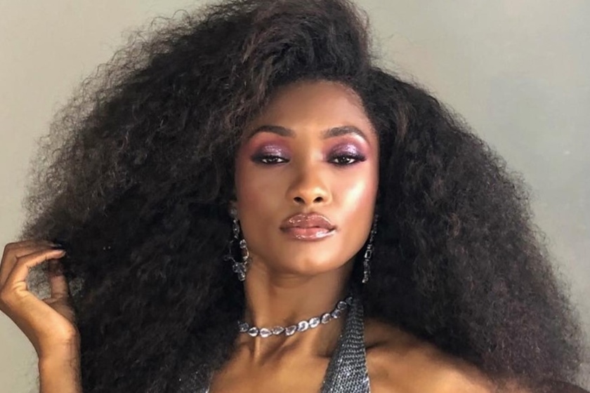 Erika Januza é uma mulher preta, de cabelo preto e crespo. Está maquiada e posa para foto - Metrópoles