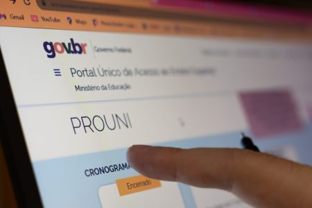 estudante aponta para tela do computador com site do Prouni