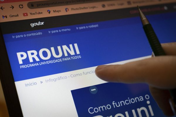 estudante aponta para tela do computador com site do Prouni