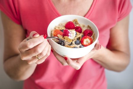 Mulher segurando prato com cereais e frutas- Metrópoles