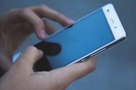 Pessoa segurando celular com WhatsApp aberto - Metrópoles