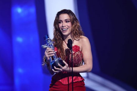 anitta de vestido vermelho segurando prêmio - metrópoles
