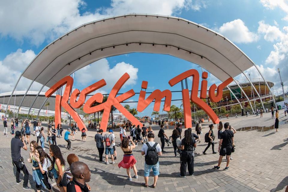 Placa com a logomarca do Rock in Rio na última edição do festival, em 2019. Pessoas tiram foto no letreiro