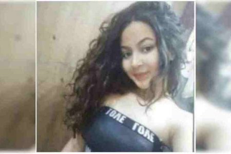 Jovem branca, de roupa preto e cabelos cacheados