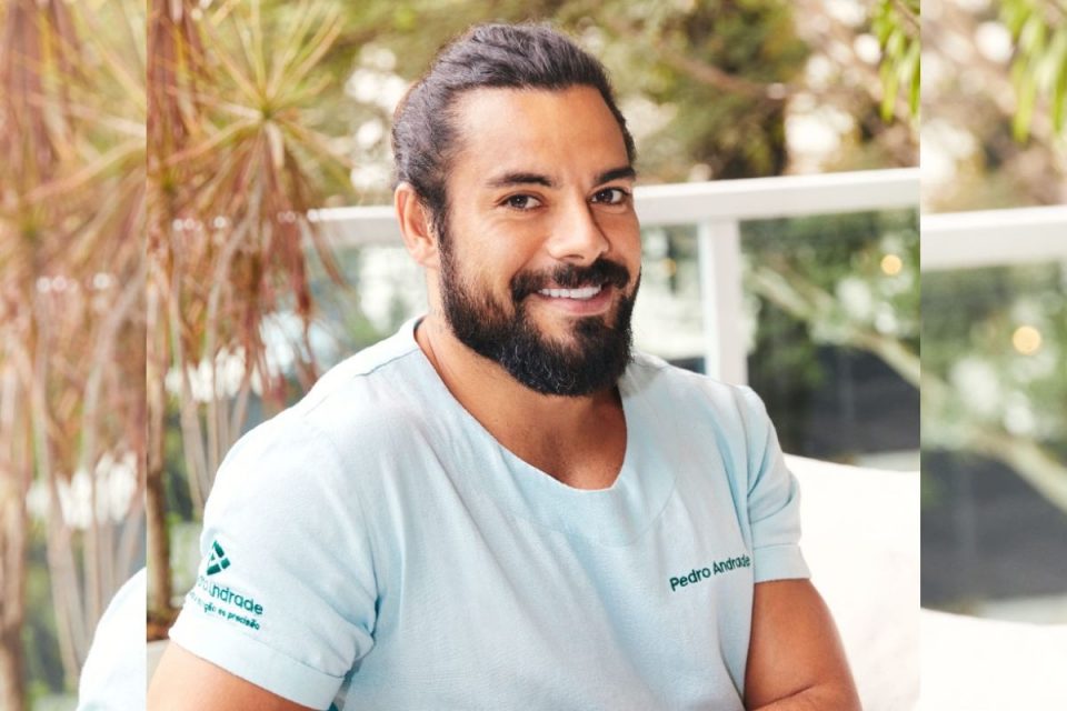 Foto colorida. Homem de barba e com roupa azul-claro