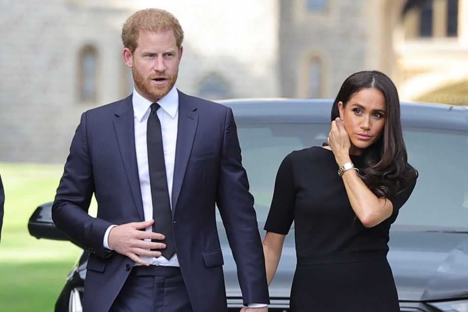 Harry está de mãos dadas com a esposa Meghan durante homenagens para a rainha Elizabeth